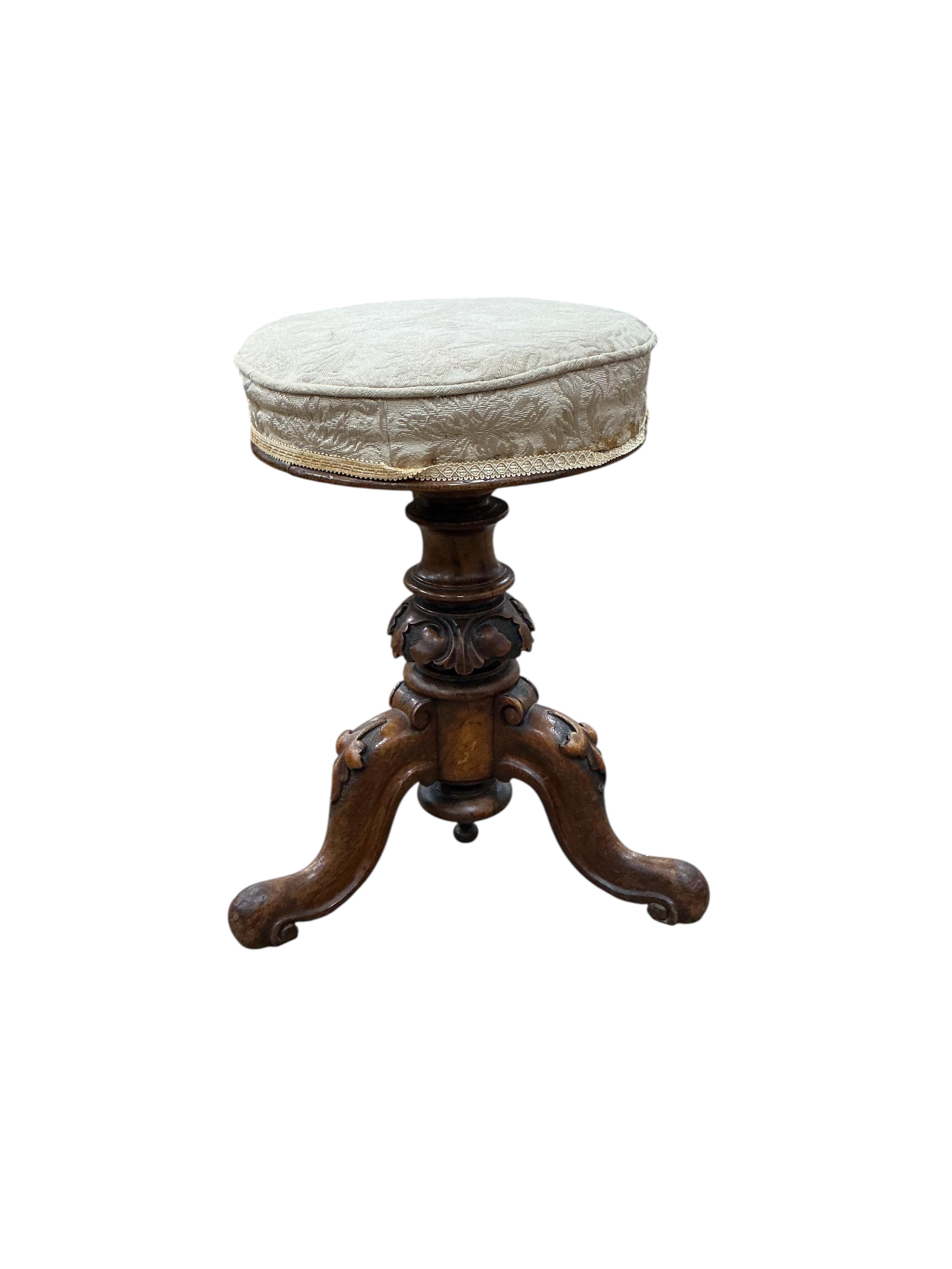 A Victorian walnut revolving piano stool